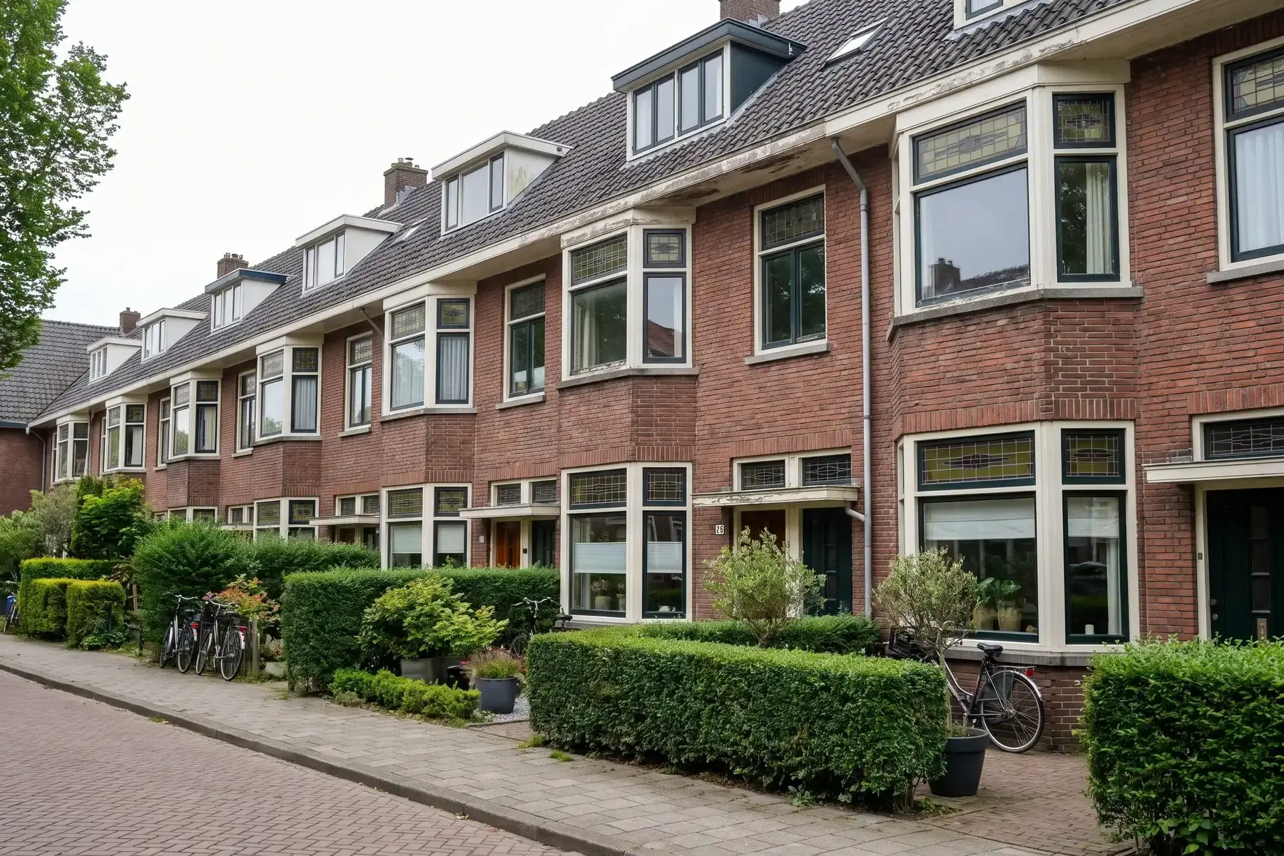 Rij jaren 30 woningen met erkers, glas-in-lood en kleine voortuinen