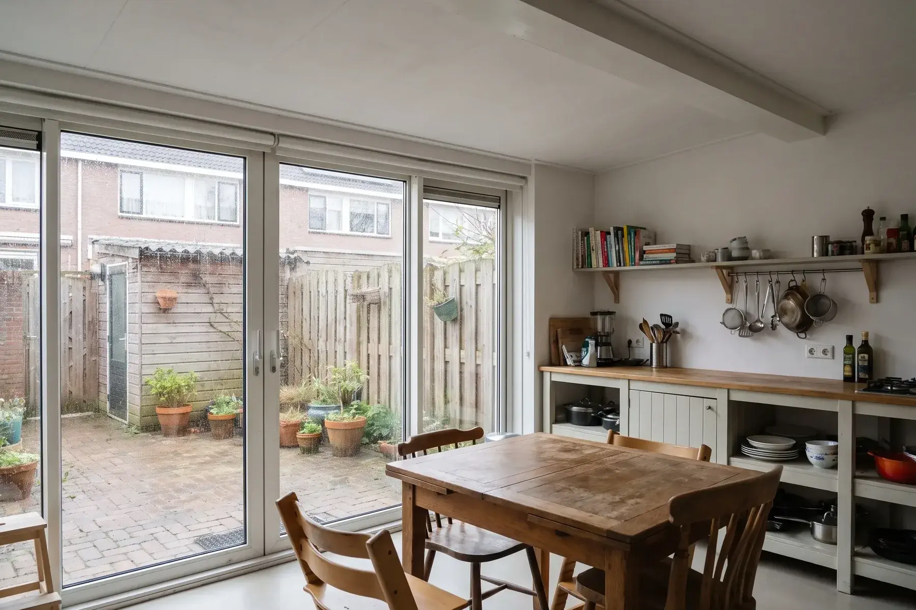 Uitbouw met een plat dak achter een rijtjeswoning, ingericht als keuken met eettafel