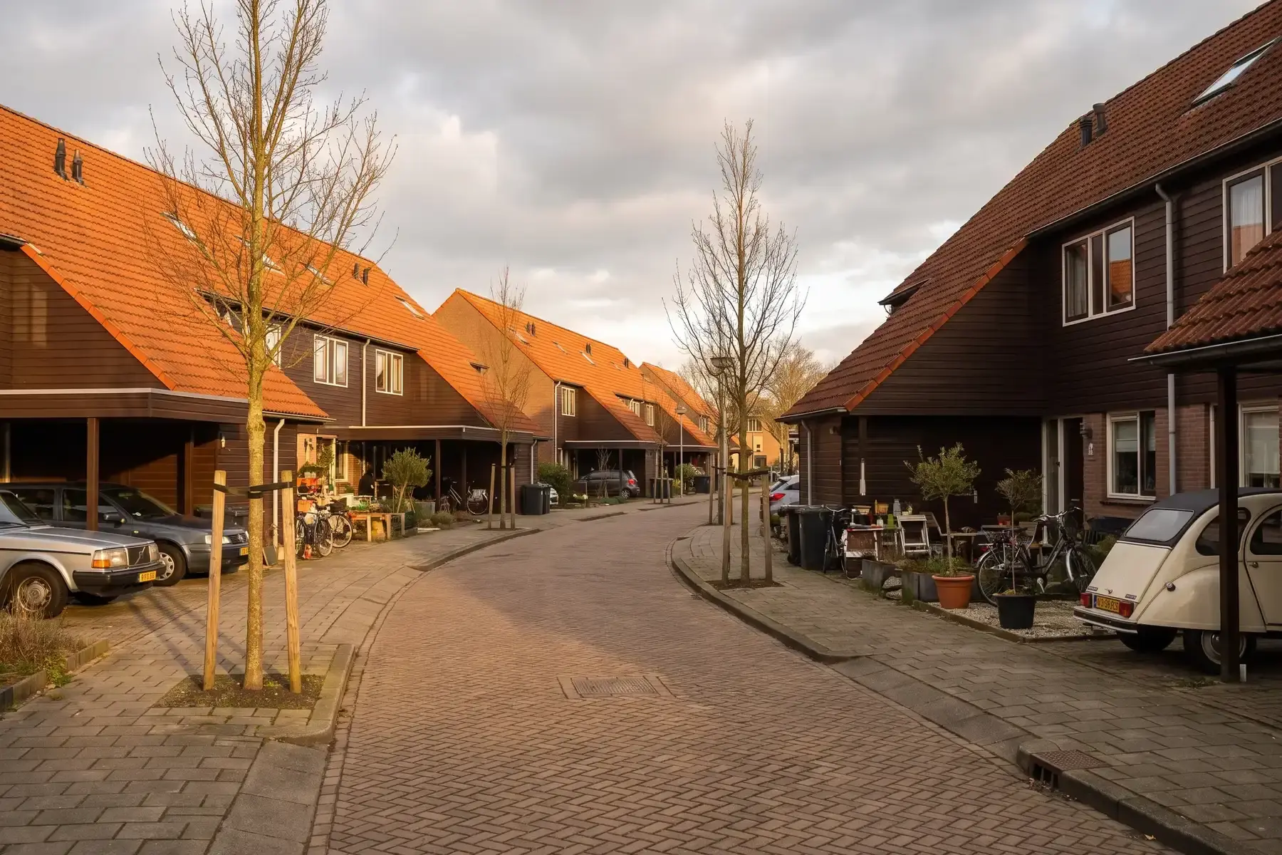 Woonerf uit de jaren zeventig met rijtjeswoningen met houten gevelbetimmering en steile daken
